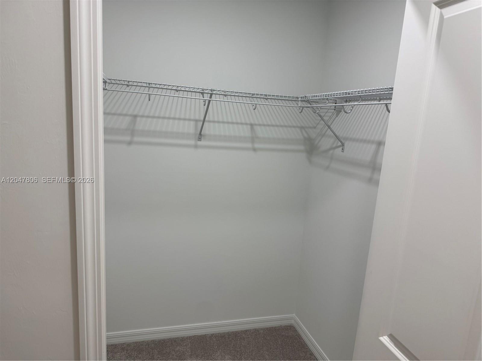 A small walk-in closet features white walls, gray carpeting, and a wire shelving unit — 5491 Double Eagle Cir # 3732, Ave Maria FL 34142, AVE MARIA, FL