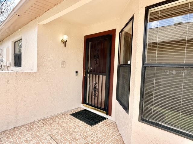 A front entryway features a tiled porch, a security screen door, and a large window — 2911 WOOLRIDGE DRIVE, ORLANDO, FL