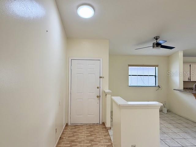 This interior view shows a room with a white door, tiled floor, and ceiling fan — 2911 WOOLRIDGE DRIVE, ORLANDO, FL