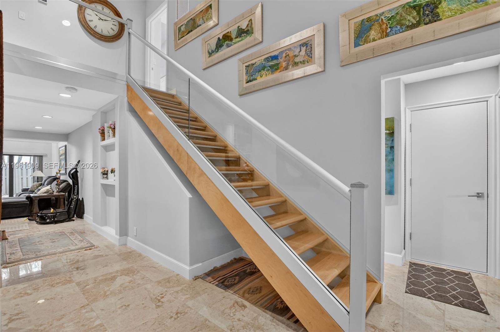 A staircase with wooden treads and a glass railing stands in a tiled foyer — 1400 NW 9th Ave # 2, Boca Raton FL 33486, BOCA RATON, FL