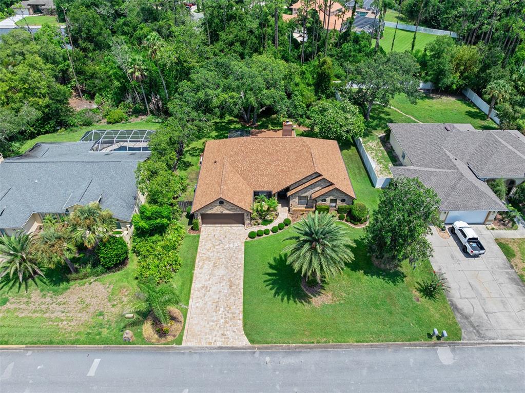 An aerial view of a single-story house with a brown roof and a paved driveway — 43 WINDING CREEK WAY, ORMOND BEACH, FL