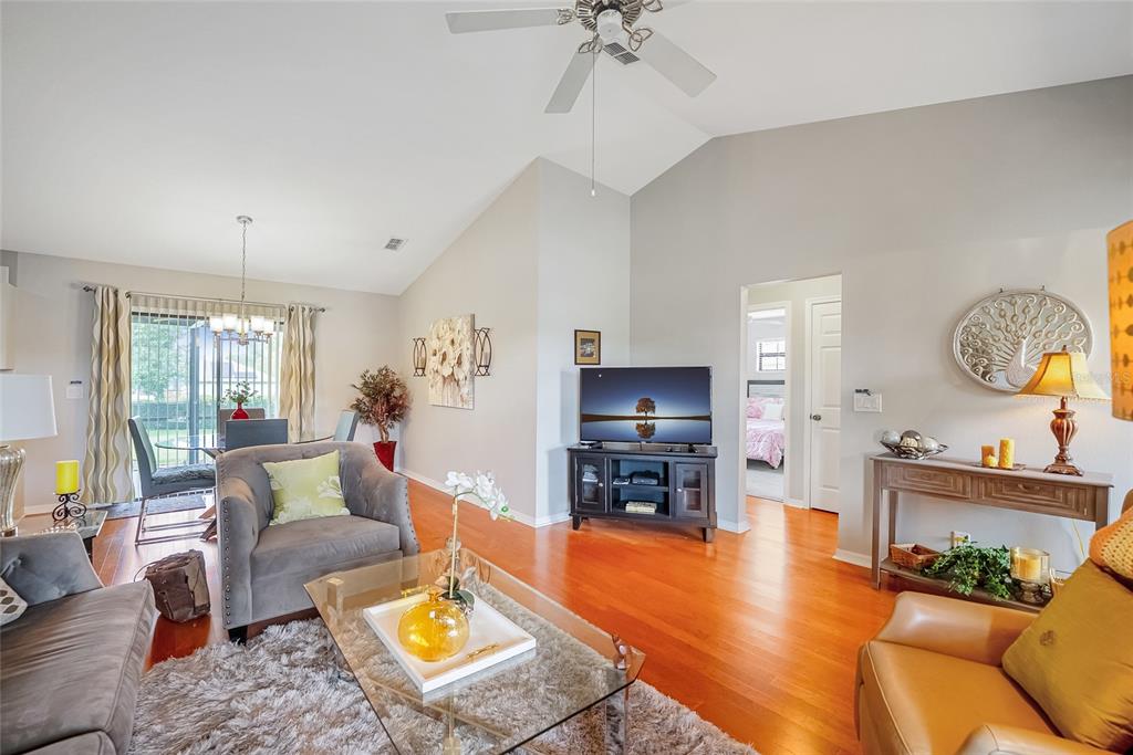 A living room features hardwood floors, a vaulted ceiling, and an open dining area — 4535 NW 34TH PLACE, OCALA, FL