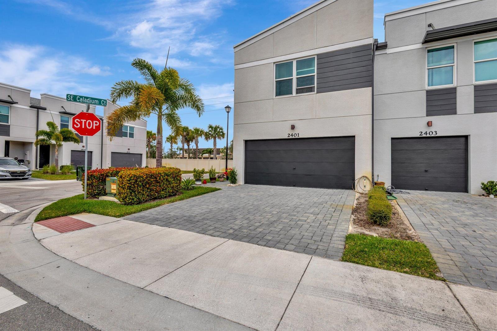 The exterior view shows two modern townhomes with gray garage doors and paved driveways — 2401 SE Tarvest Way, Stuart FL 34997, STUART, FL