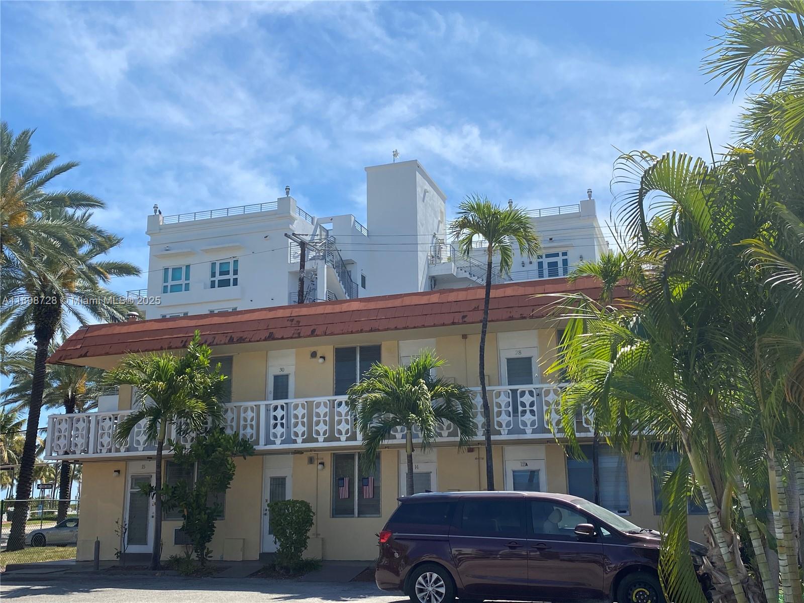 A two-story apartment building with a red roof and white balcony railings sits outdoors — 441 Collins Ave # 27, Miami Beach FL 33139, MIAMI BEACH, FL