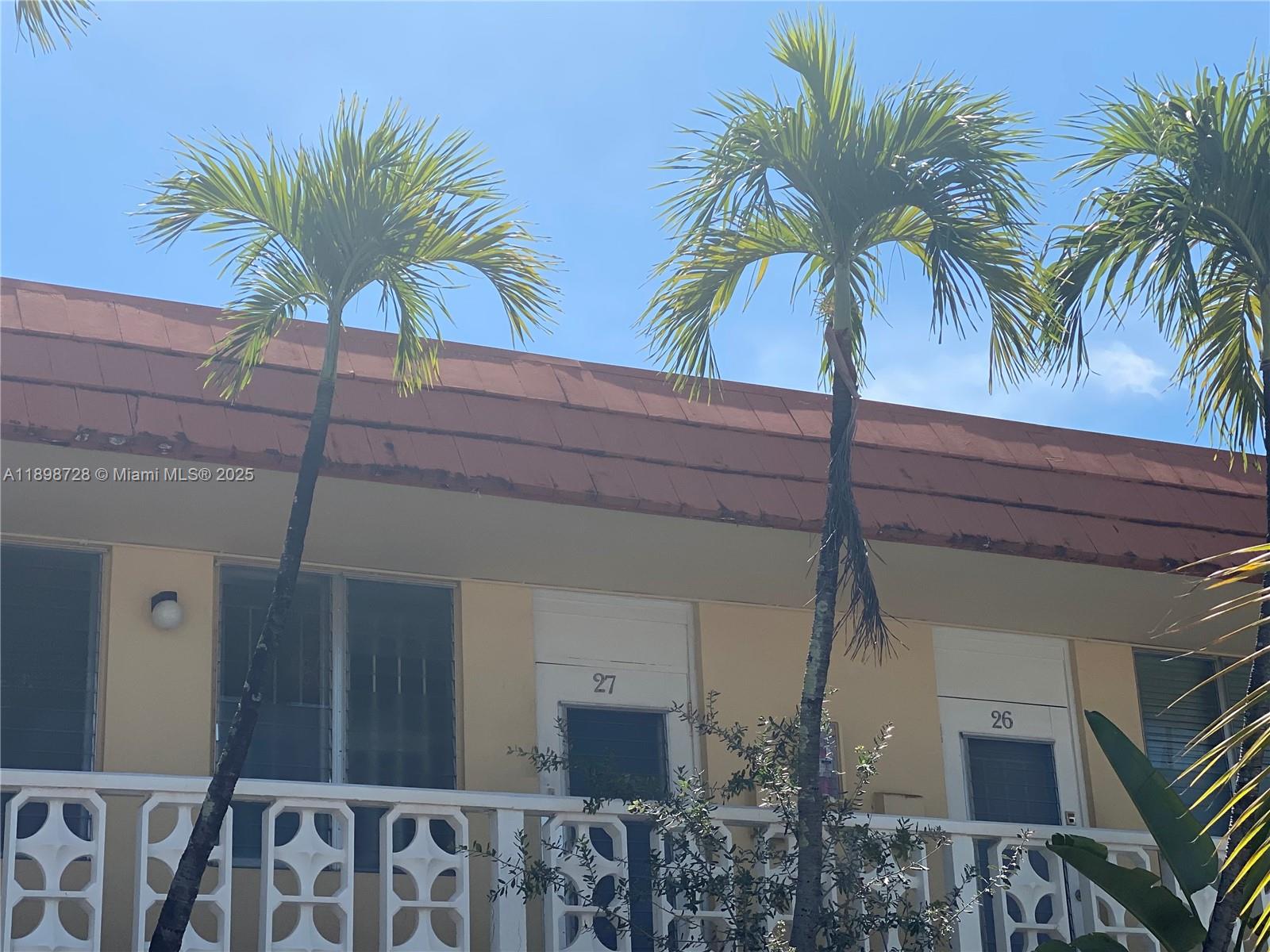 Exterior view of a two-story building with numbered apartment doors and palm trees — 441 Collins Ave # 27, Miami Beach FL 33139, MIAMI BEACH, FL