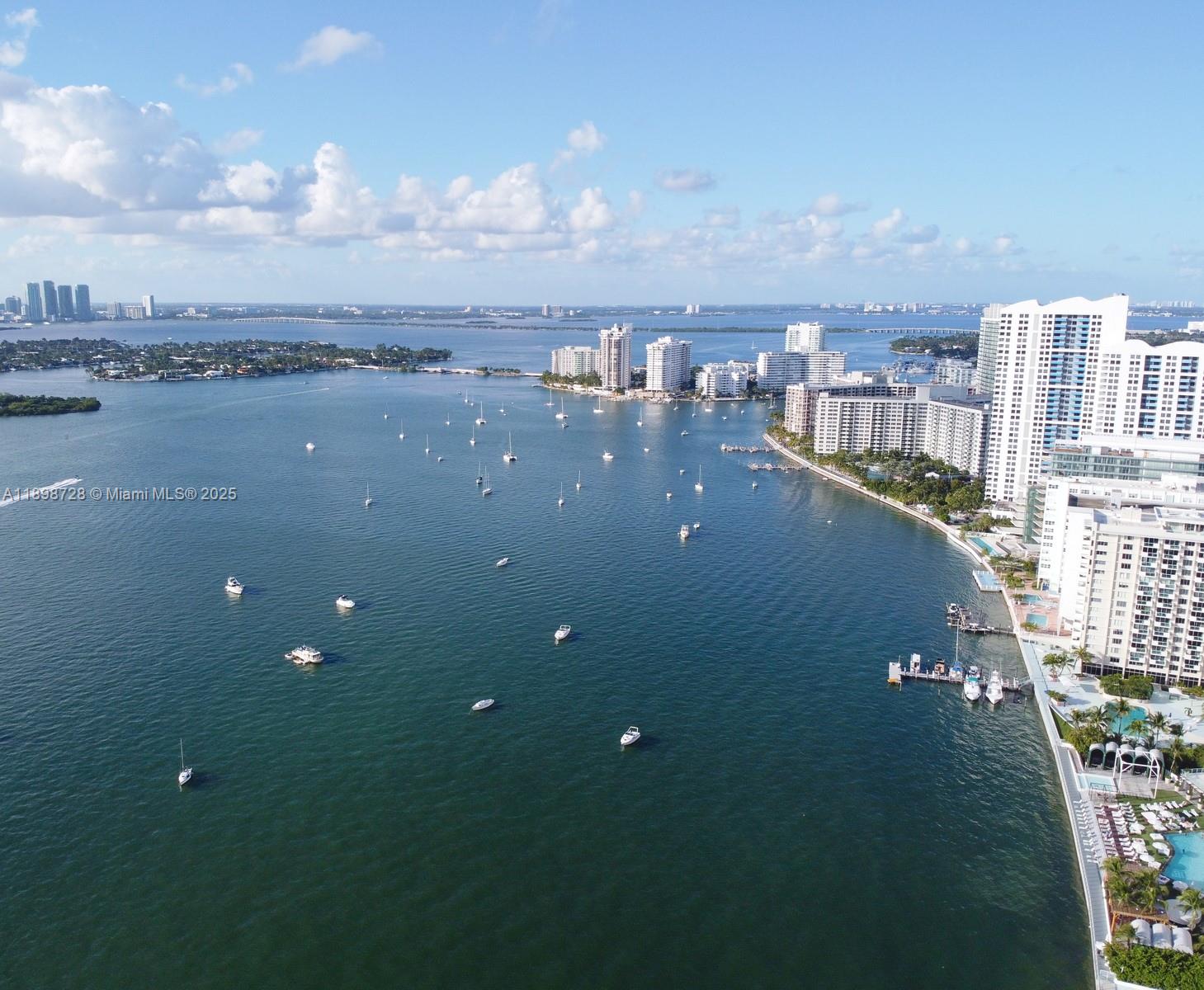 An aerial view shows a bay with many anchored boats near a coastal city skyline — 441 Collins Ave # 27, Miami Beach FL 33139, MIAMI BEACH, FL