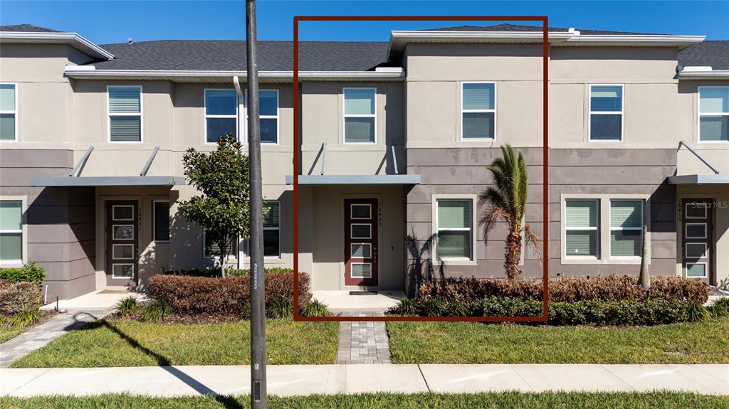 A two-story townhouse exterior features a brown front door, gray siding, and a small palm tree — 16425 PRAIRIE SCHOOL DRIVE, WINTER GARDEN, FL