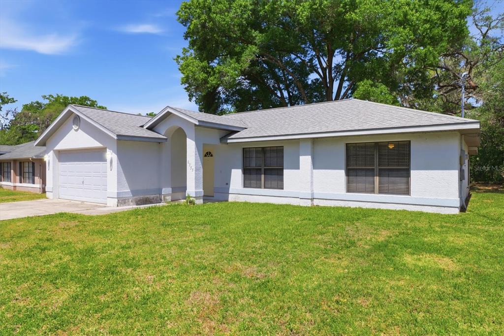 A single-story house with a white stucco exterior, a gray shingled roof, and a garage — 6355 E RUSH STREET, INVERNESS, FL