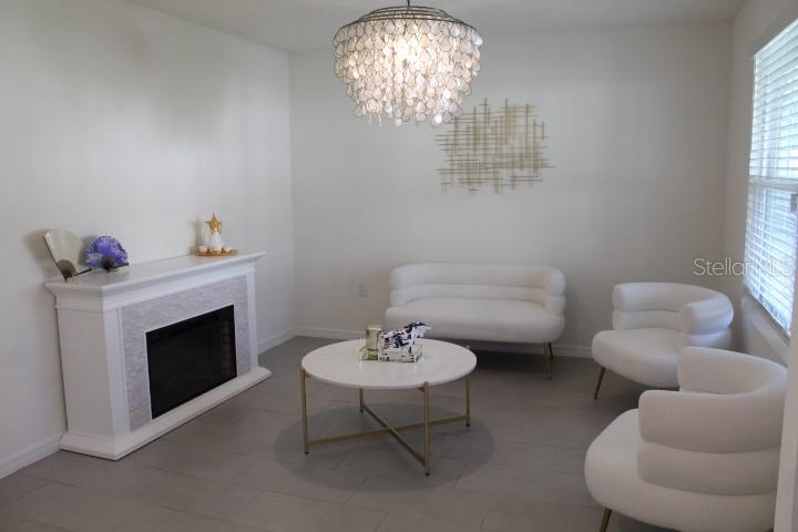 A living room features a white fireplace, a round coffee table, and white curved seating — 2182 NW 246TH TERRACE, NEWBERRY, FL