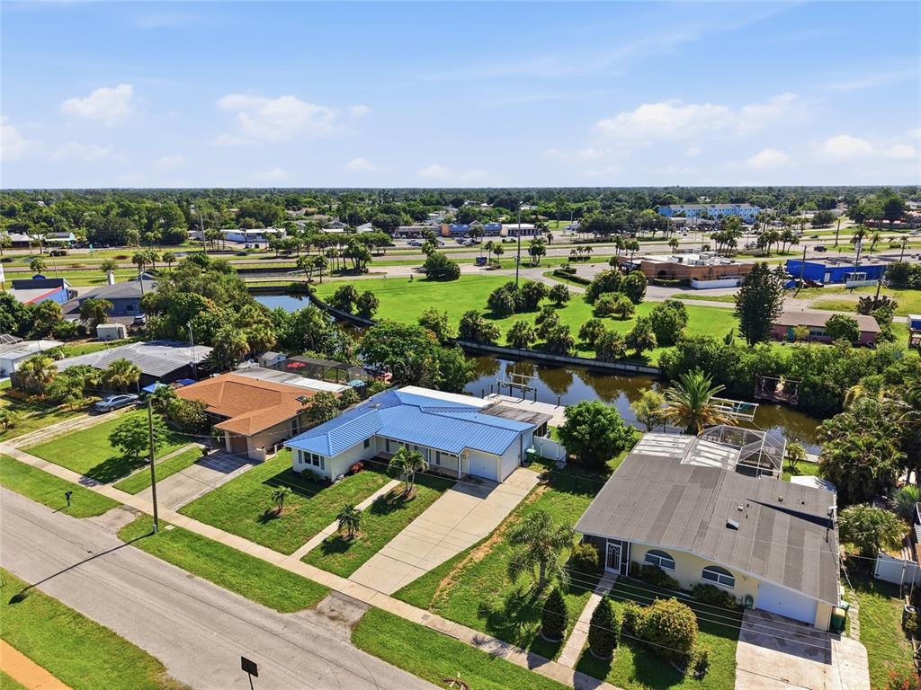 An aerial view shows three houses along a street with a canal in the backyard — 181 DUXBURY AVENUE, PORT CHARLOTTE, FL