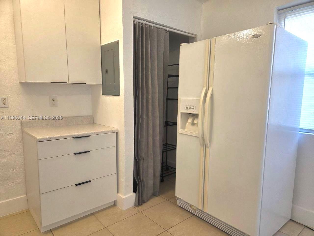 A kitchen features white cabinets, a white refrigerator, and a curtained pantry closet — 34 SW 6th Ave # 4, Dania Beach FL 33004, DANIA BEACH, FL
