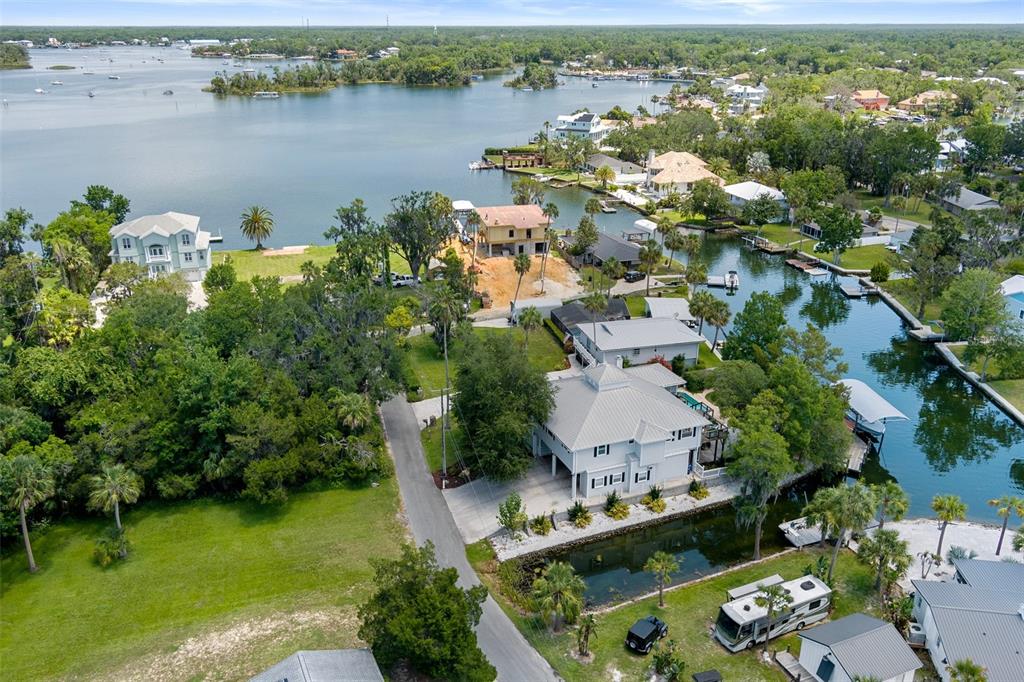 An aerial view shows waterfront homes, a canal, and a large lake with boats — 1035 N APPALACHIAN TERRACE, CRYSTAL RIVER, FL