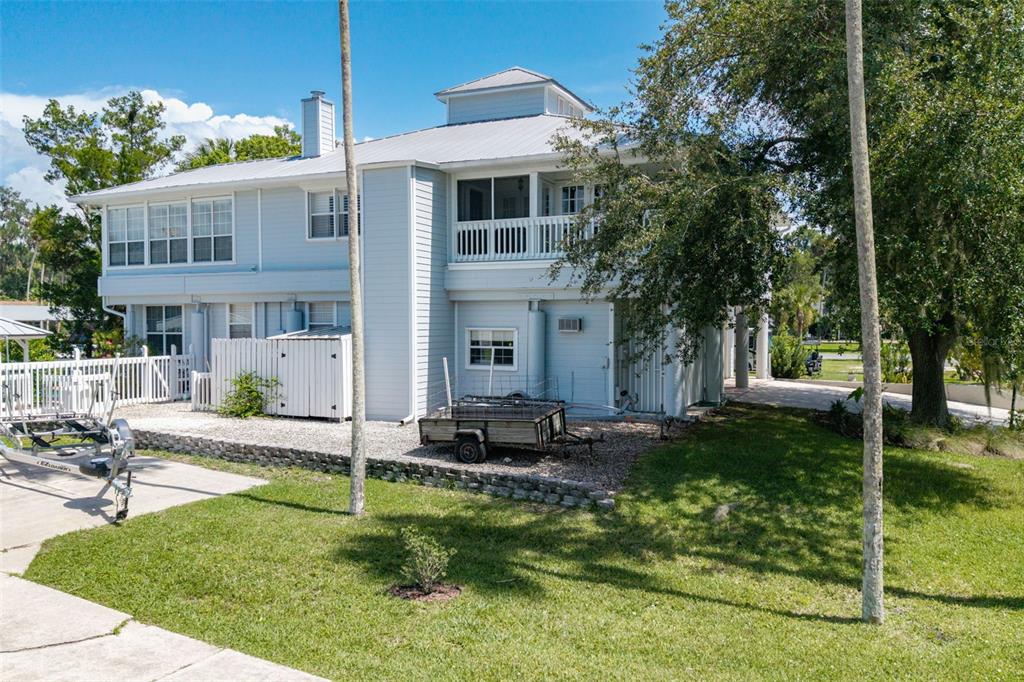 A light blue two-story house with a metal roof, a balcony, and a utility trailer — 1035 N APPALACHIAN TERRACE, CRYSTAL RIVER, FL