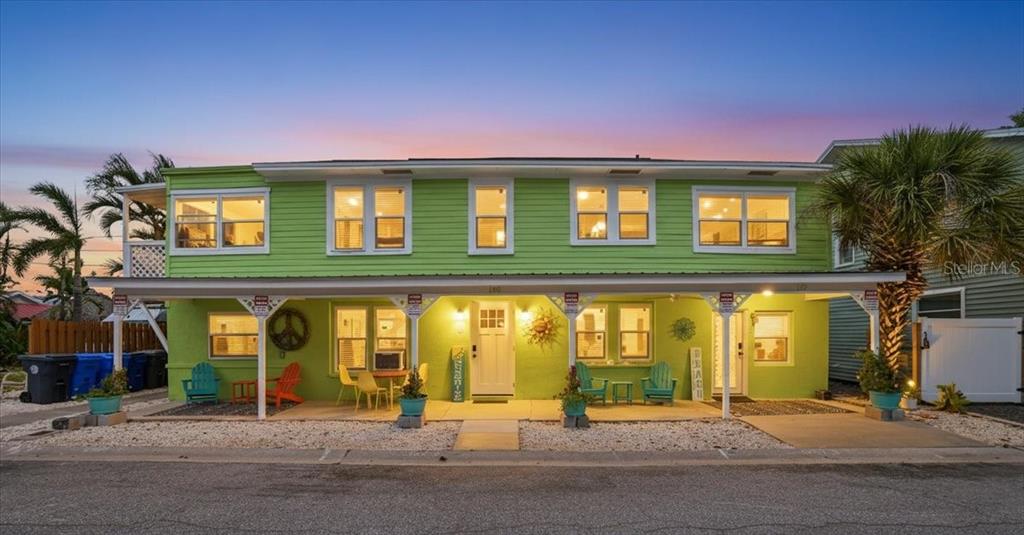 A two-story, lime green house with a covered front porch and outdoor seating areas — 130 86TH TERRACE, TREASURE ISLAND, FL