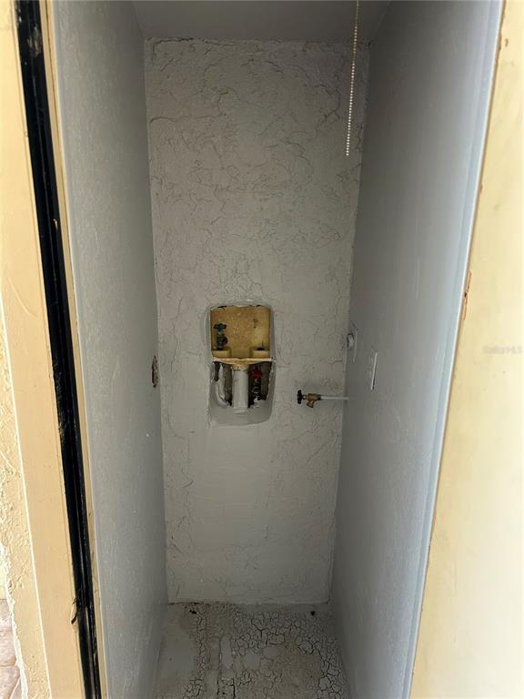 A small utility closet features a recessed plumbing box and a single wall-mounted water valve — 6301 58TH STREET N UNIT 501, PINELLAS PARK, FL