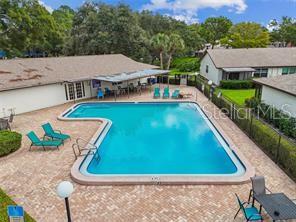 An aerial view of an L-shaped swimming pool surrounded by a brick patio and buildings — 2472 ENTERPRISE ROAD UNIT 6, CLEARWATER, FL