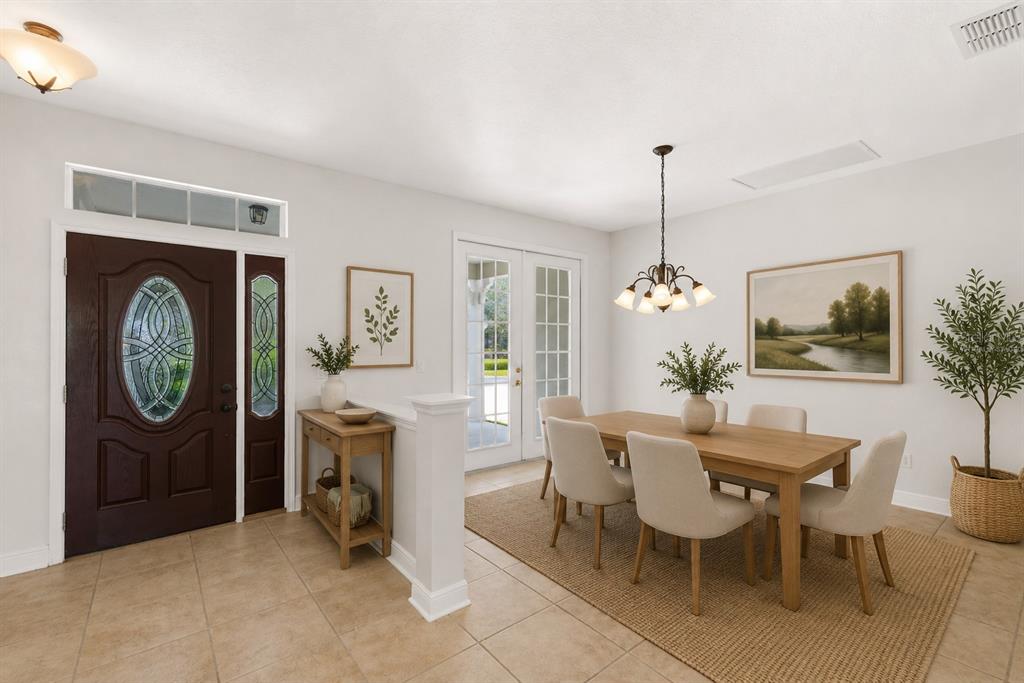 A dining area with a wooden table, chairs, and a front door entryway — 6363 SEDONA LEAF COURT, WINDERMERE, FL