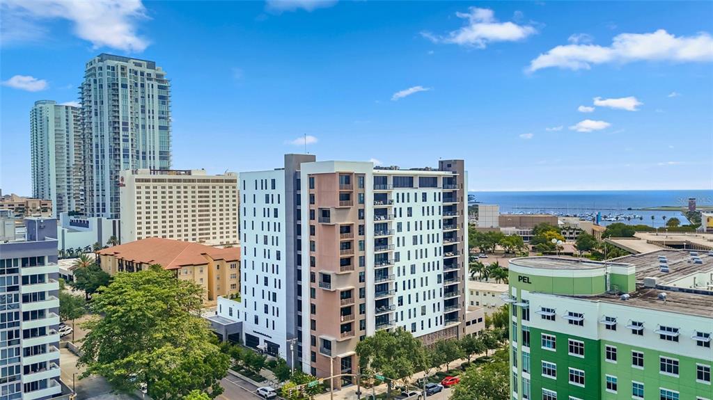An aerial view shows several modern high-rise apartment buildings near a marina and the ocean — 199 DALI BOULEVARD UNIT 1106, ST PETERSBURG, FL