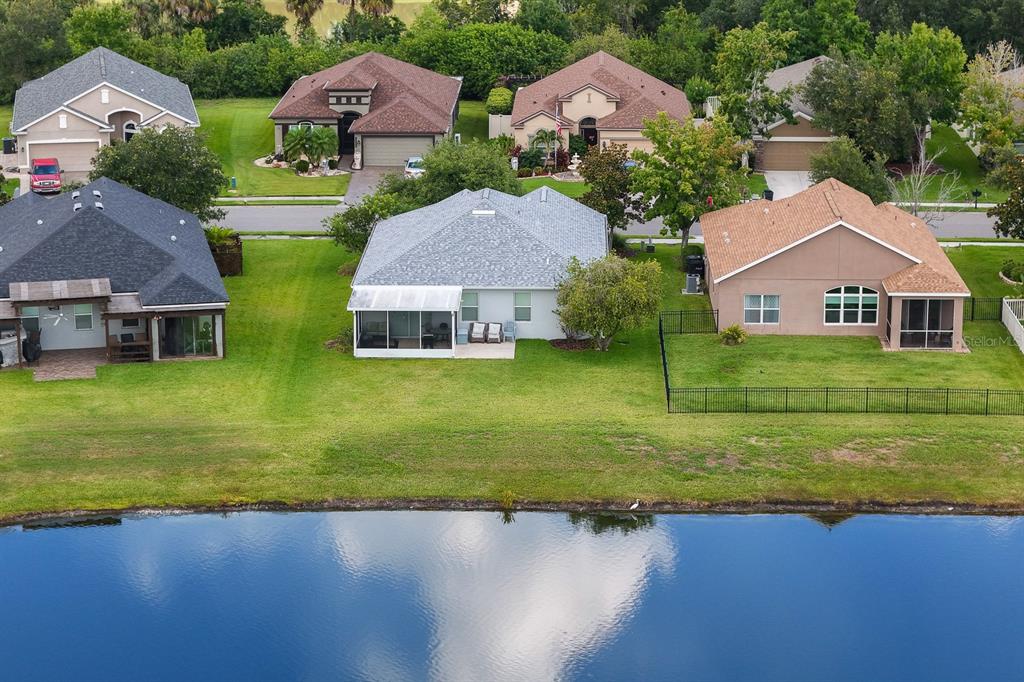 A light-colored house exterior features a front door with a screen, a walkway, and seating — 11223 82ND STREET E, PARRISH, FL