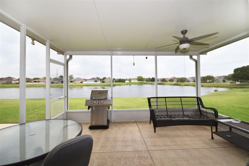 A covered patio features a ceiling fan, outdoor furniture, and sliding glass doors leading indoors — 11223 82ND STREET E, PARRISH, FL