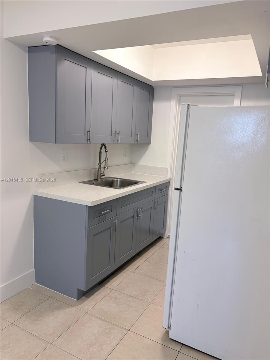 A kitchen features gray shaker-style cabinets, a stainless steel sink, and white countertops — 31 NW 163rd St # 65, Miami FL 33169, MIAMI, FL