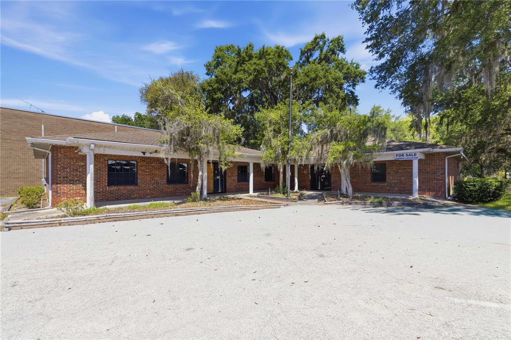 A one-story brick commercial building with a covered walkway and a large paved parking lot — 12300 SE 135TH AVENUE, OCKLAWAHA, FL