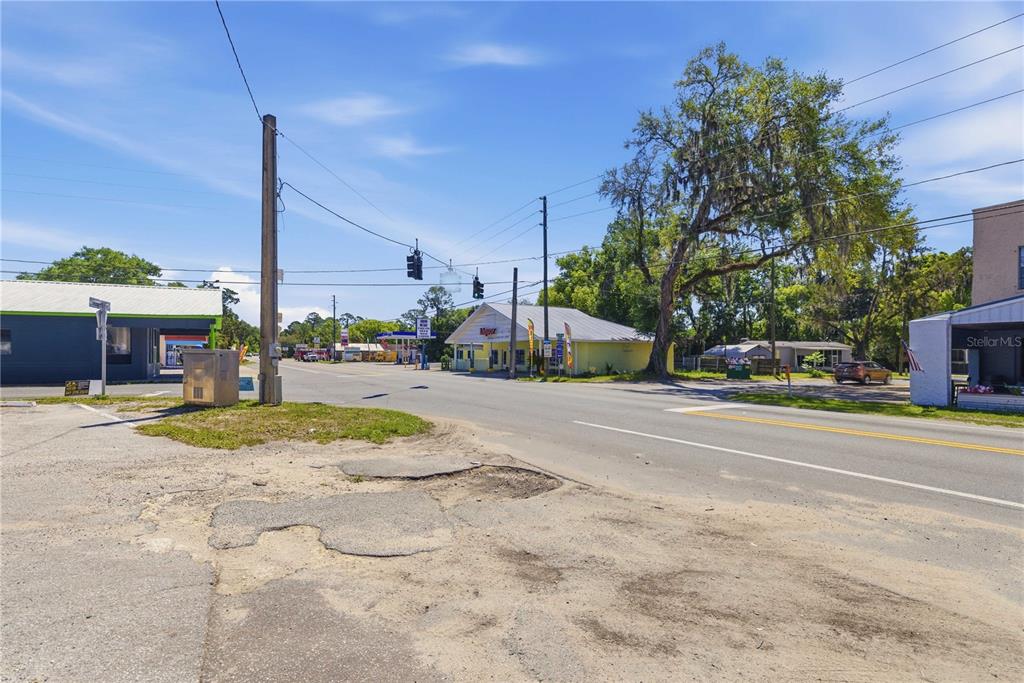A view of a street intersection with commercial buildings, power lines, and a paved road — 12300 SE 135TH AVENUE, OCKLAWAHA, FL