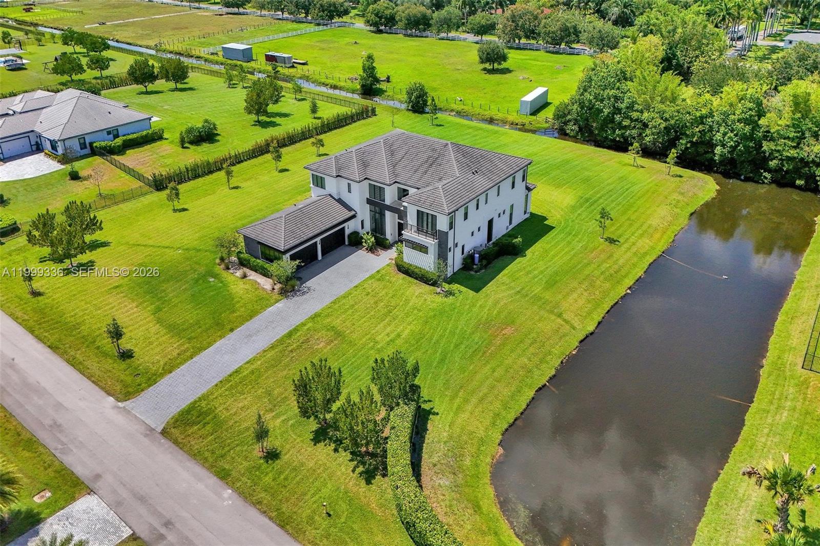 An aerial view shows a large two-story house with a driveway and a pond — 17811 SW 58th St, Southwest Ranches FL 33331, SOUTHWEST RANCHES, FL