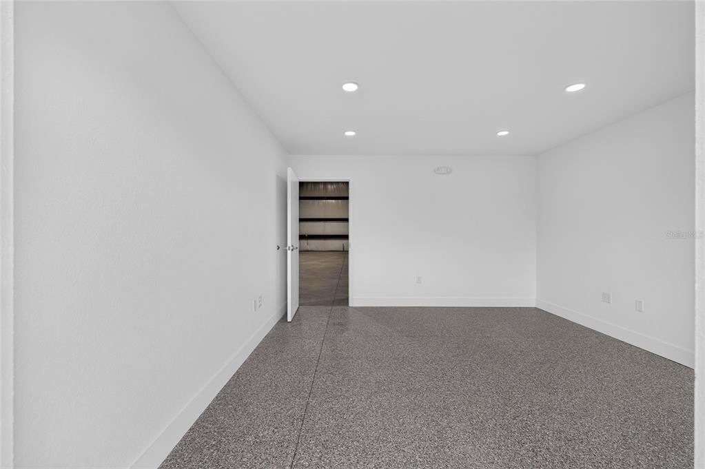 A minimalist room with white walls, recessed lighting, and grey speckled flooring — 5425 SE 133 PLACE, BELLEVIEW, FL