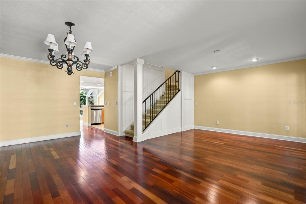A living room with hardwood floors, a chandelier, and a staircase with a black railing — 1134 WASHINGTON AVENUE UNIT 13C, WINTER PARK, FL