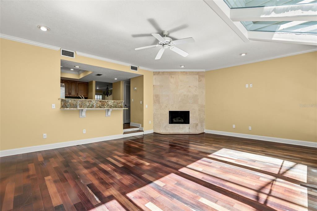 A living room features hardwood floors, a stone fireplace, and a ceiling fan — 1134 WASHINGTON AVENUE UNIT 13C, WINTER PARK, FL