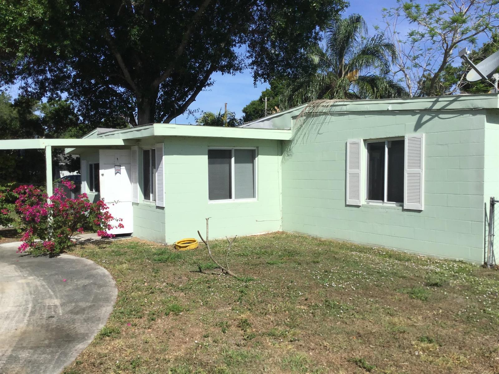 A light green concrete block house with white shutters and a small front yard — 364 Johnston Street, Fort Pierce FL 34982, FORT PIERCE, FL