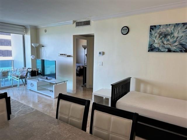 A living area features a television, a bed, and a doorway leading to another room — 4001 S Ocean Dr # 9L, Hollywood FL 33019, HOLLYWOOD, FL