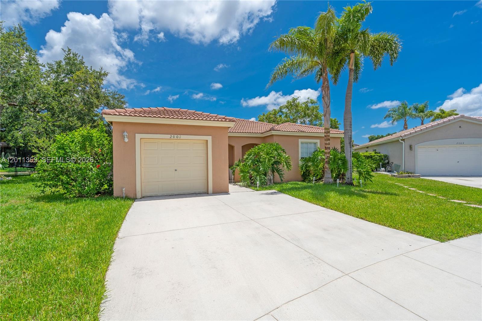 A single-story house with a tan stucco exterior, tile roof, and a concrete driveway — 2001 SW 104th Ave, Miramar FL 33025, MIRAMAR, FL