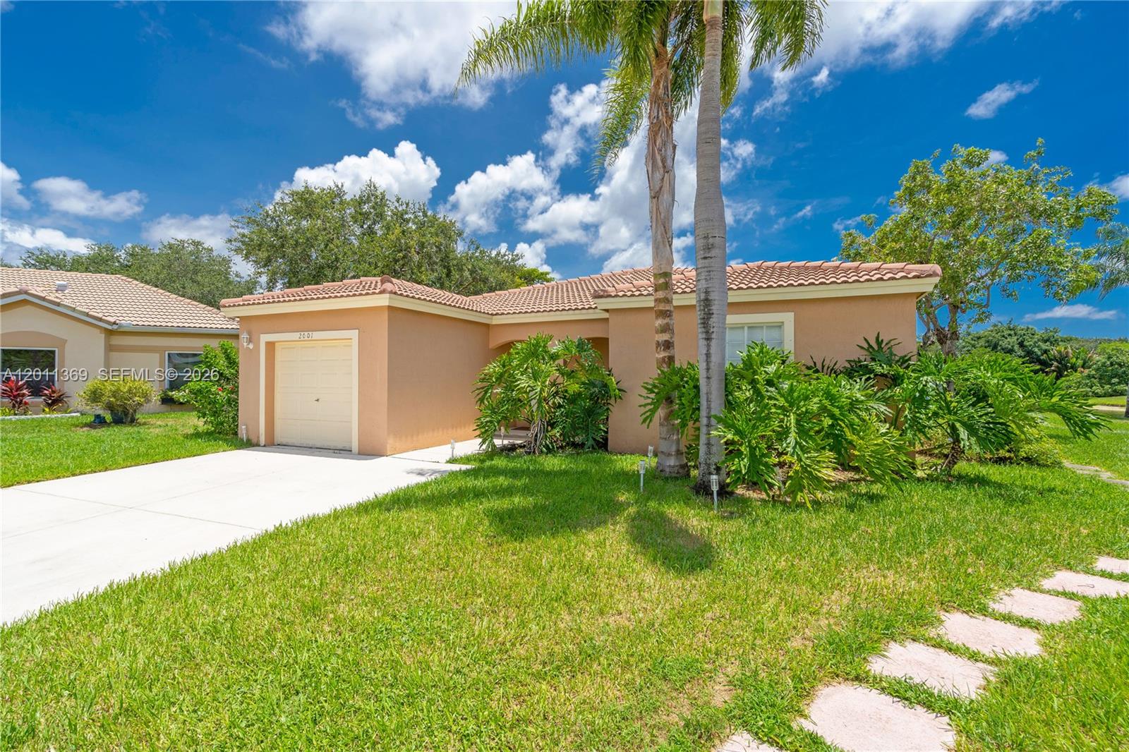 A single-story house with a tan stucco exterior, a tile roof, and a palm tree — 2001 SW 104th Ave, Miramar FL 33025, MIRAMAR, FL