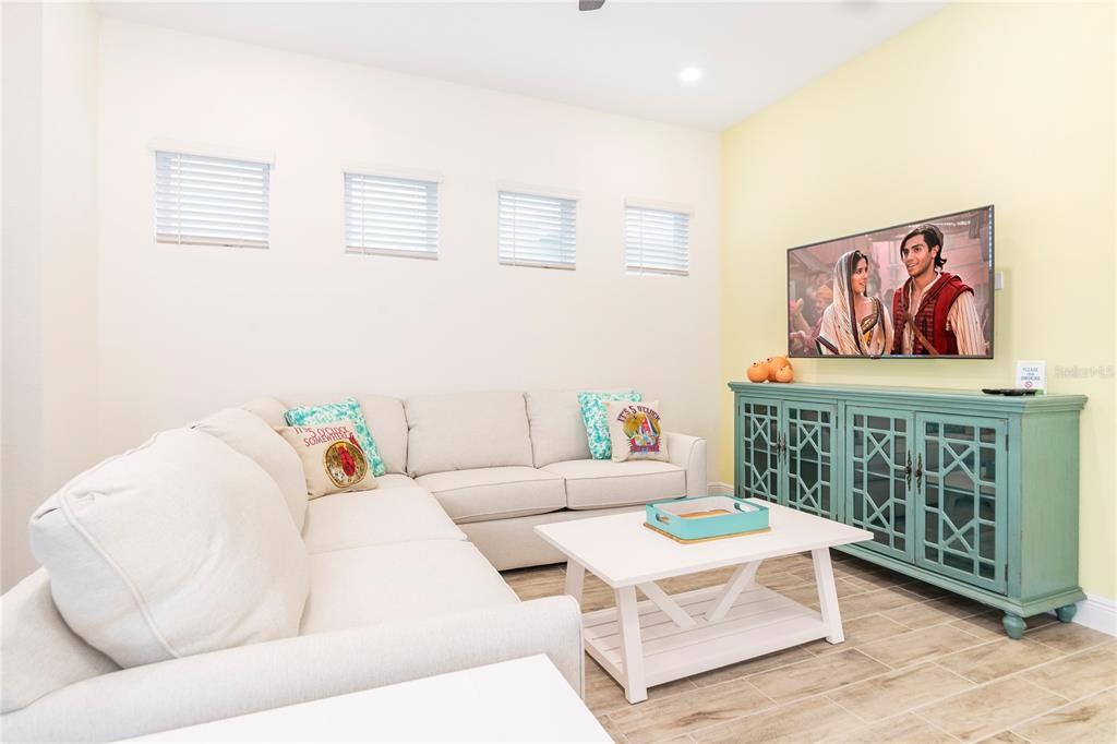 A living room features a beige sectional sofa, a white coffee table, and a teal console — 2988 SALTED RIM ROAD, KISSIMMEE, FL