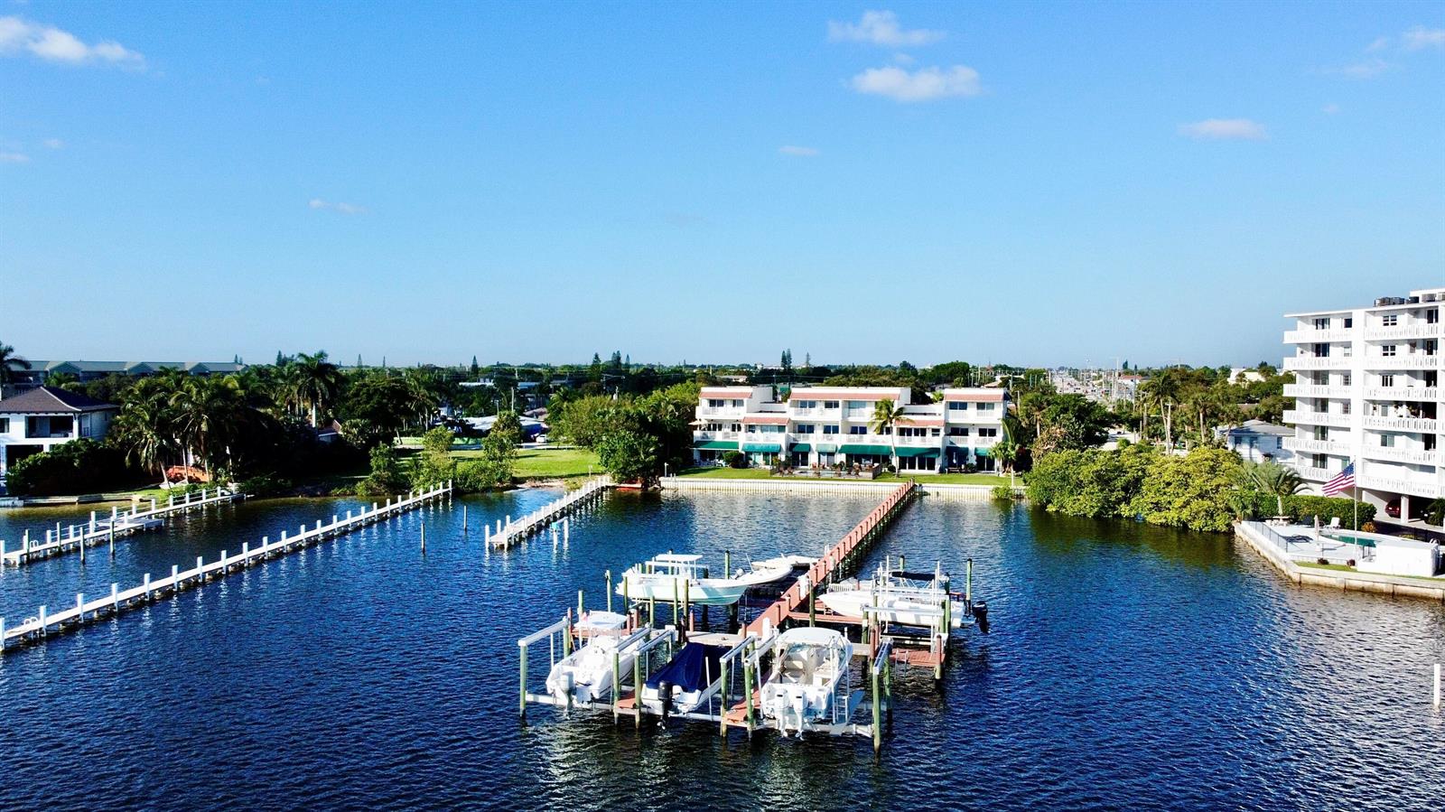 An aerial view of a waterfront apartment building with a private boat dock and slips — 324 N Lake Drive, Lantana FL 33462, LANTANA, FL
