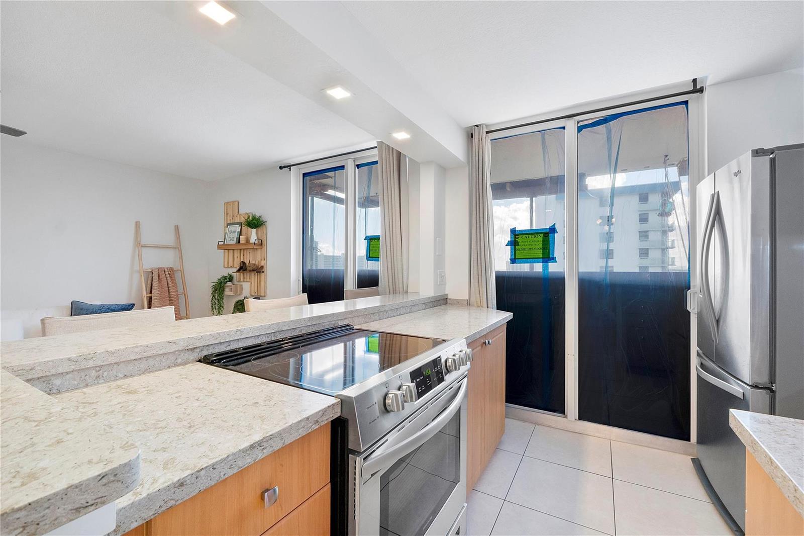 A kitchen with light wood cabinets, granite countertops, and a stainless steel stove — 1505 N Riverside Drive # 1003, Pompano Beach FL 33062, POMPANO BEACH, FL