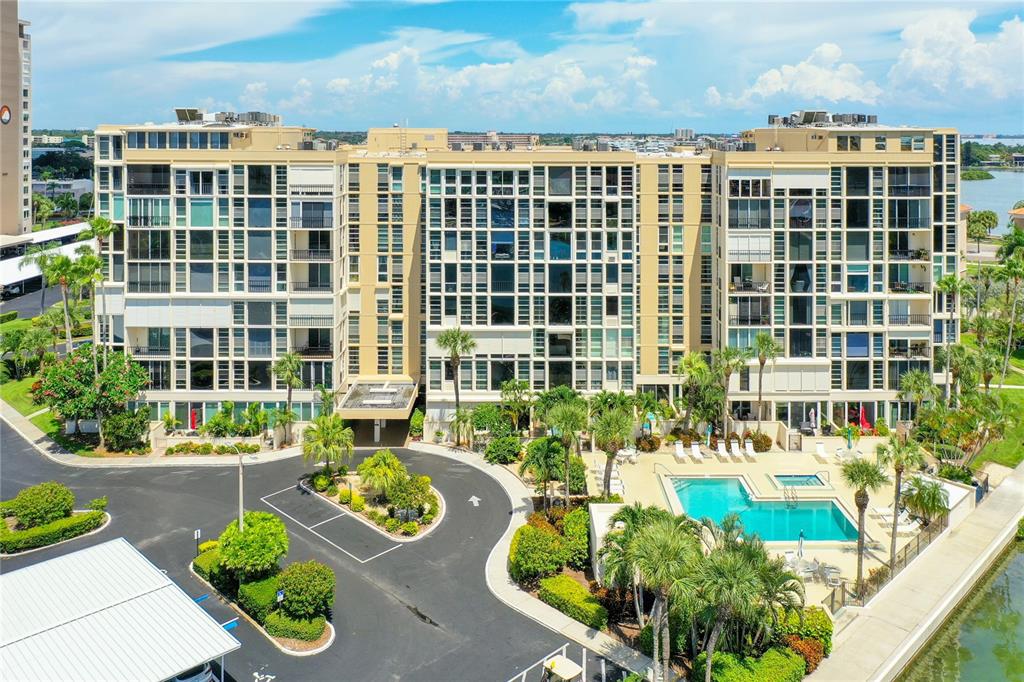 An aerial view of a multi-story apartment building with a swimming pool and parking lot — 7400 SUN ISLAND DRIVE UNIT 503, SOUTH PASADENA, FL