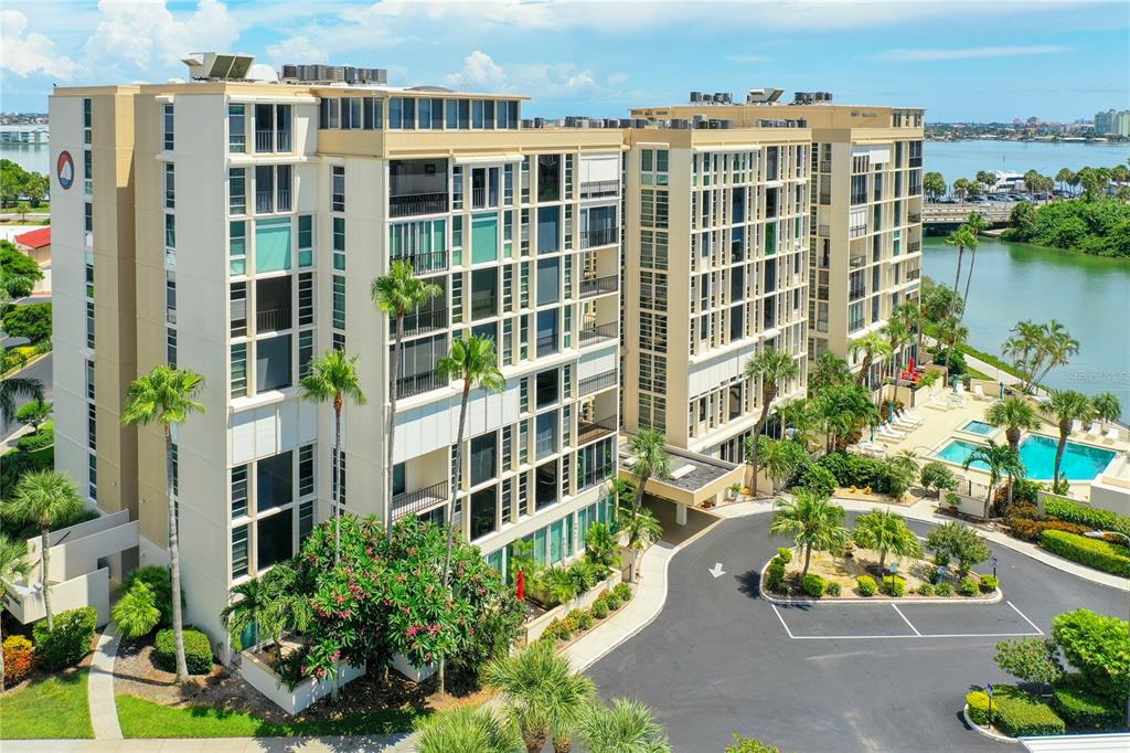 An aerial view of a multi-story apartment building with a pool and waterfront access — 7400 SUN ISLAND DRIVE UNIT 503, SOUTH PASADENA, FL