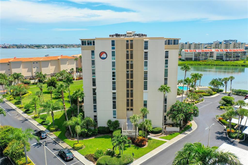 An aerial view of a multi-story apartment building surrounded by palm trees and water — 7400 SUN ISLAND DRIVE UNIT 503, SOUTH PASADENA, FL