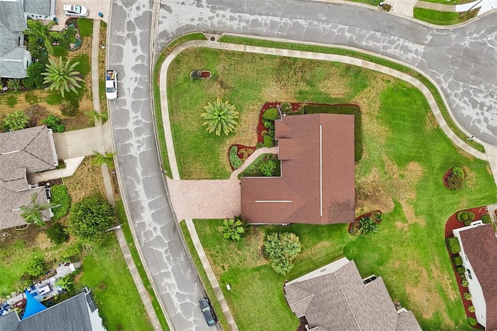 An aerial view shows a single-story house with a brown roof on a corner lot — 8328 PAVILION DRIVE, HUDSON, FL