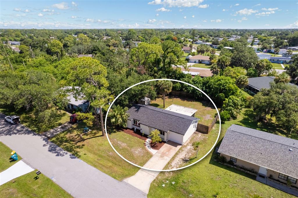 An aerial view shows a single-story house with a dark roof and a driveway — 2500 LINTON LANE, PORT CHARLOTTE, FL
