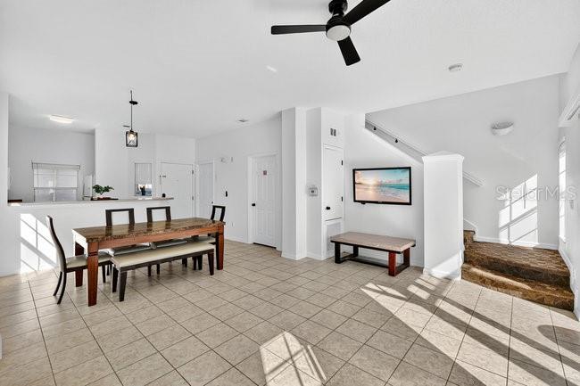 A dining area with a wooden table and chairs sits on a tiled floor — 1070 PARK RIDGE CIRCLE, KISSIMMEE, FL