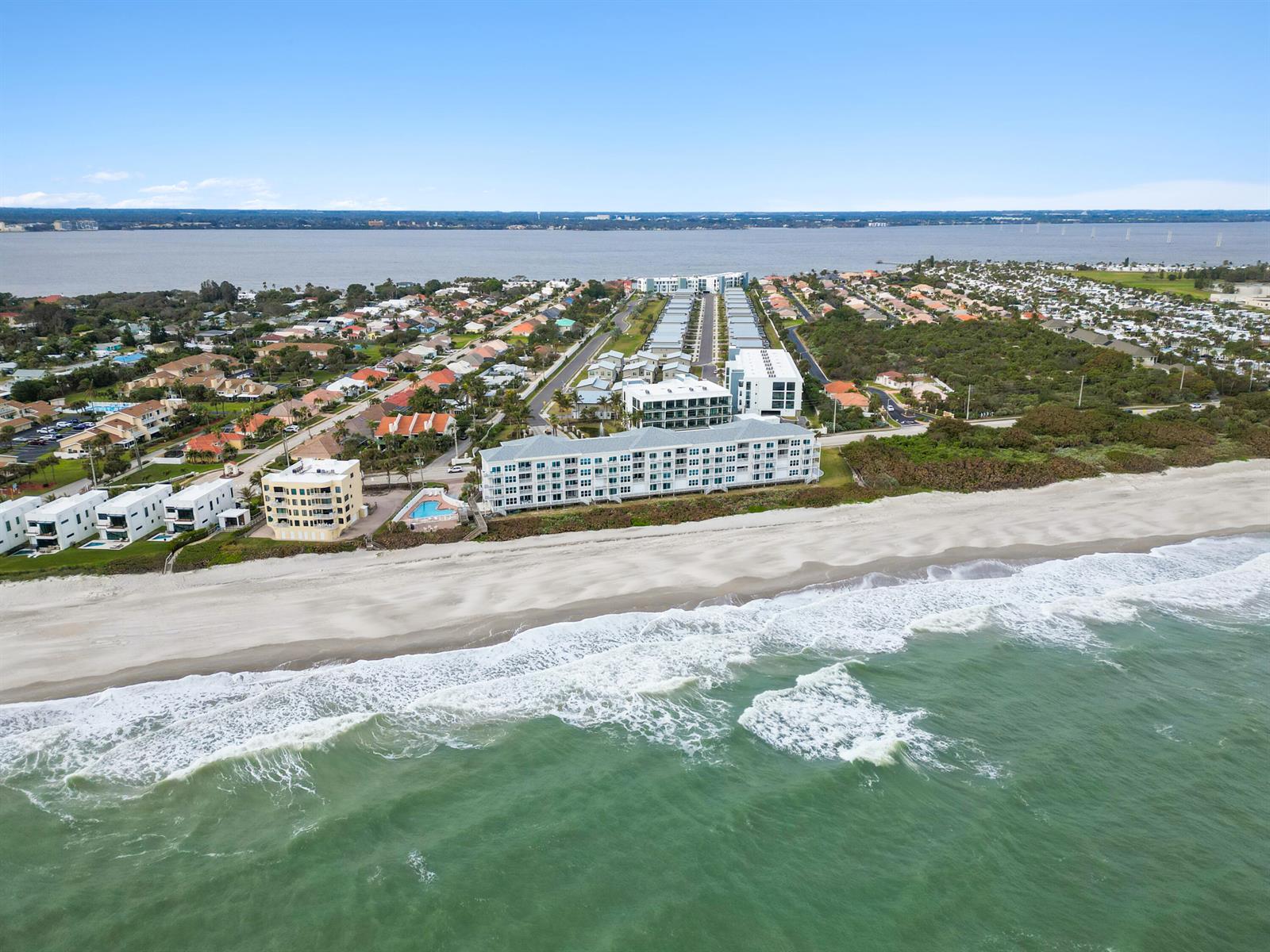 An aerial view shows a multi-story beachfront condominium complex with a pool near the ocean — 475 Strand Drive, Melbourne Beach FL 32951, MELBOURNE BEACH, FL