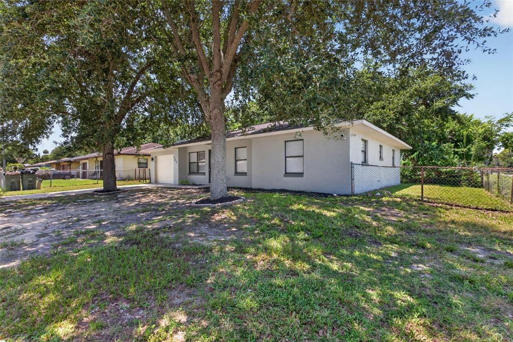 A single-story gray house with a garage and large trees in the front yard — 502 LOOMIS TRAIL, DAYTONA BEACH, FL