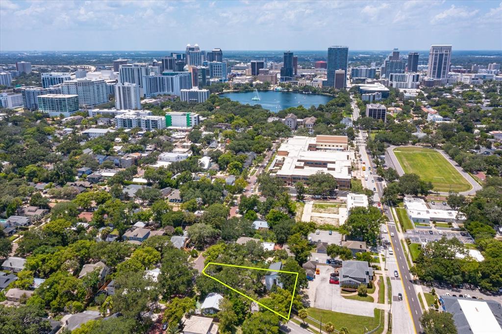 An aerial view shows a residential lot outlined in yellow near a city skyline — 200 N THORNTON AVENUE, ORLANDO, FL