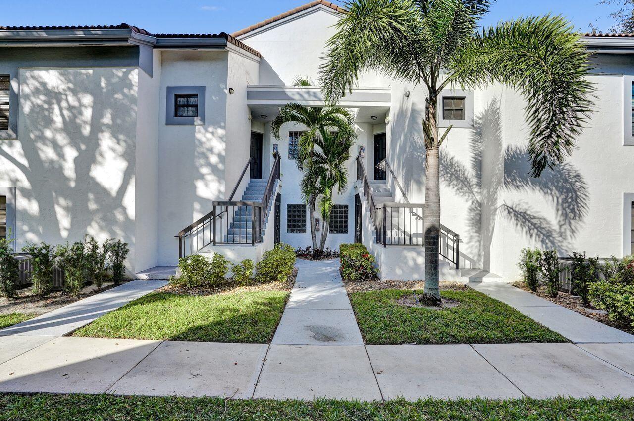 A two-story residential building exterior features symmetrical staircases, a central palm tree, and white stucco — 5415 Verona Drive # I, Boynton Beach FL 33437, BOYNTON BEACH, FL