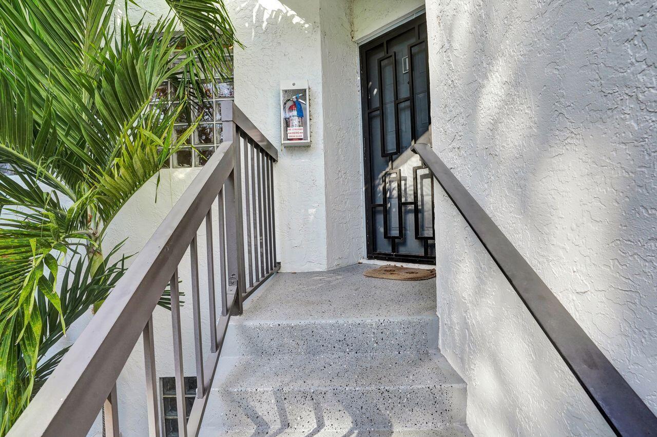 Concrete stairs lead to a front door with a decorative metal security gate — 5415 Verona Drive # I, Boynton Beach FL 33437, BOYNTON BEACH, FL