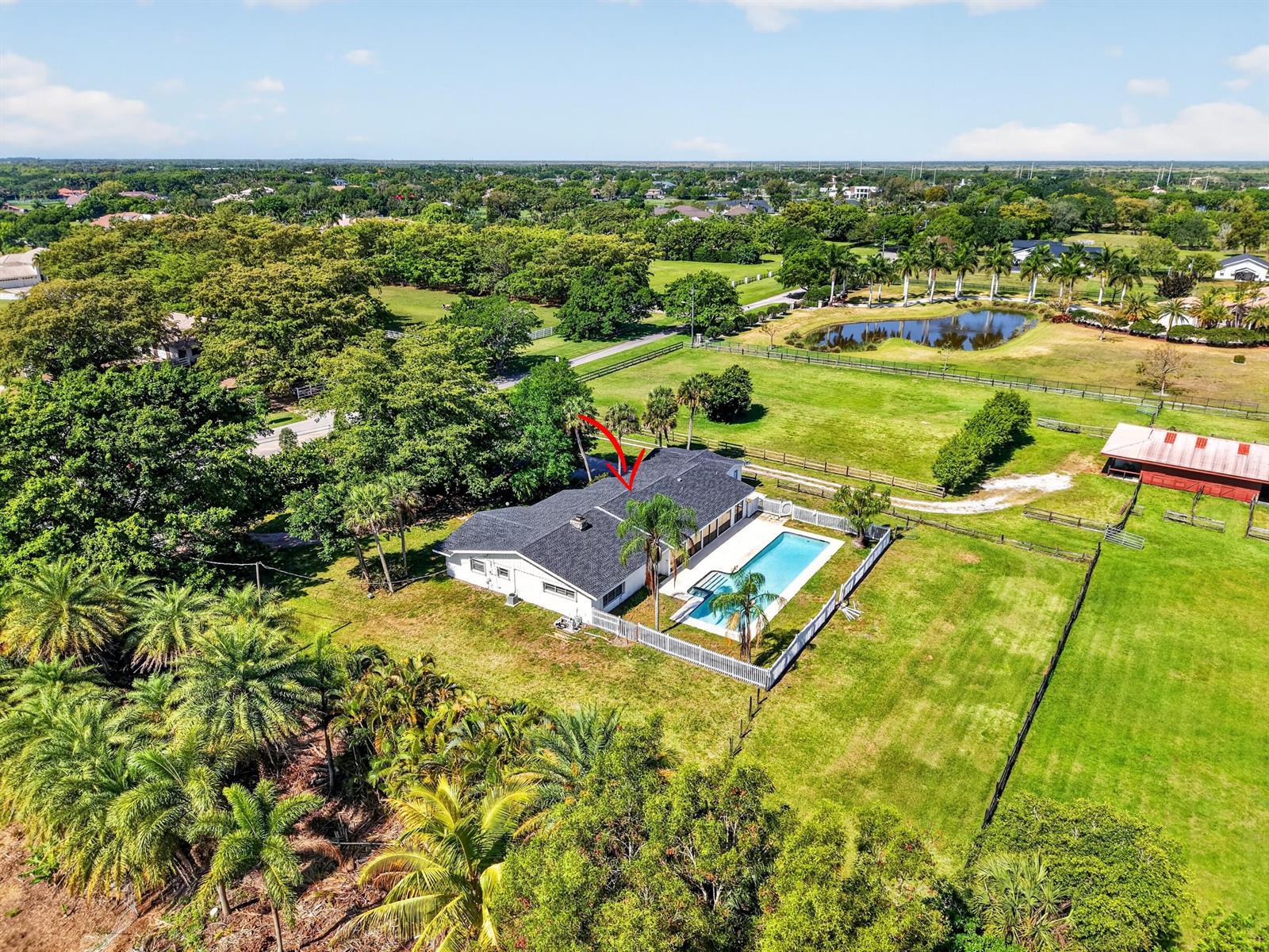 An aerial view shows a single-story house with a pool, fenced yard, and surrounding trees — 10157 La Reina Road, Delray Beach FL 33446, DELRAY BEACH, FL